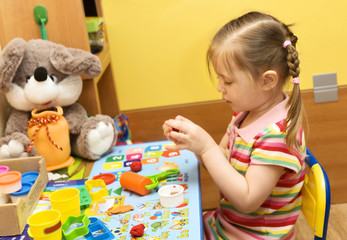 girl playing with plasticine