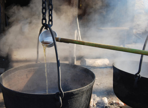making maple syrup by boiling the sap in a cauldron