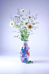 Vase with bouquet of chamomiles