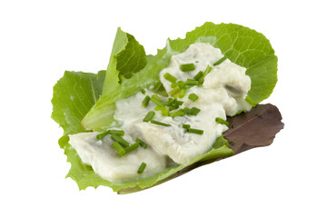 herring in creme sauce on lettuce leaves