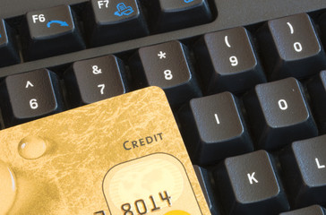 Macro shot of a gold credit card lying on a computer keyboard