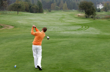 A golfer strikes a tee shot