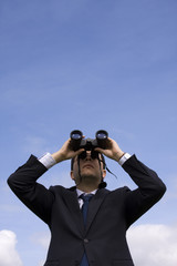 Businessman looking through binoculars