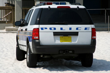 back of beach police car parked on sandy beach © Christopher Nolan