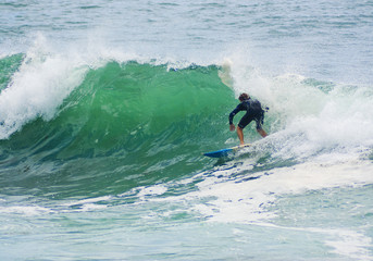 surfer surfs big wave
