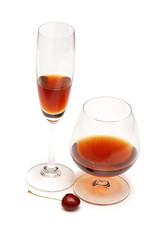 Glass of wine and cherries isolated on white