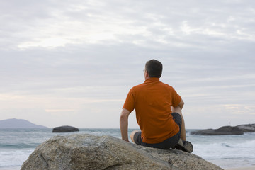 Man sitting on a rock at the sea