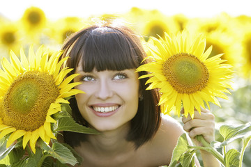 Young pretty woman on a sunflowers background