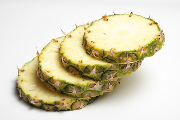 Slices of fresh pineapple on a white background.