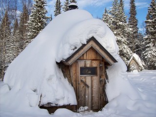 Jede Menge Schnee auf einer kleinen Holzhütte