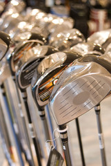 New golf clubs for sale in shop with blurred background