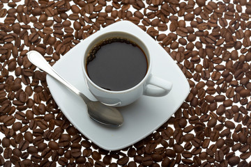 cup of coffee on coffee beans