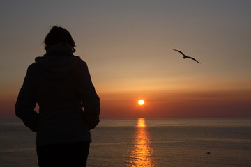 femme devant le coucher de soleil 