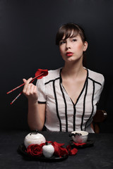 a beautiful sexy girl eats rose petals with chopsticks