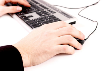 Image of hands pushing keys of a computer mouse and keyboard