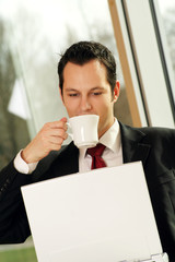 successful business man is drinking a cup of coffee