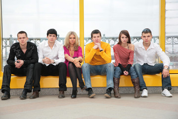 six young persons sit on footbridge