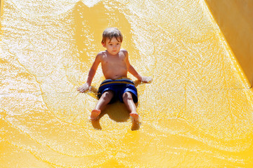 Young boy going down a waterslide