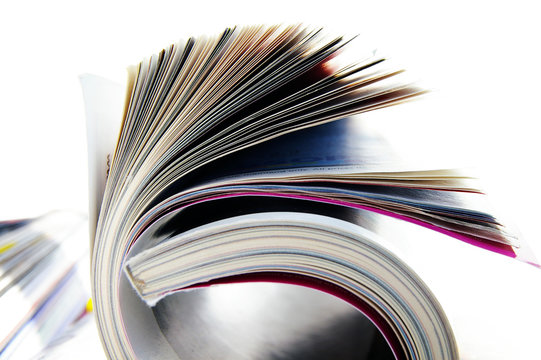 Closeup of rolled magazine pages, on white