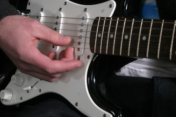 Fingers strumming guitar cords