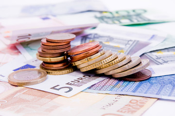 Euro banknotes with various coins