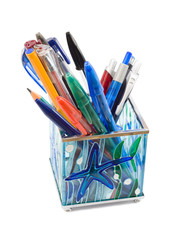Glass pen holder with pens, isolated on white