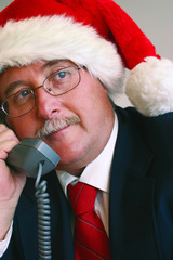 businessman in santa hat talking on telephone