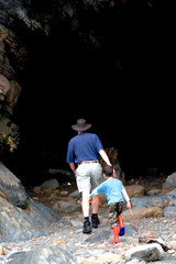 Obraz premium A father leading his son into a mysterious cave