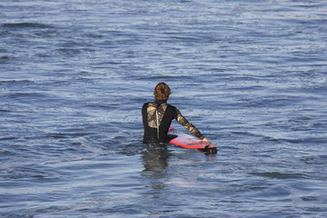 Fototapeta na wymiar surfer wchodzi do wody z jego pokładzie