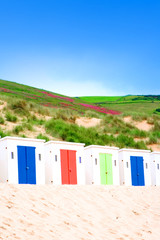 Obraz na płótnie Canvas Rows of sun huts along a sandy beach 