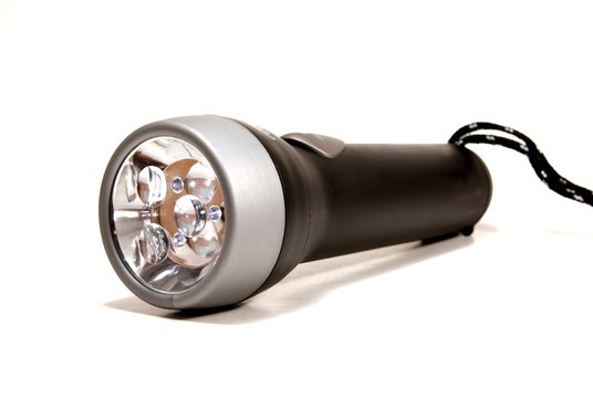 a black flashlight torch on a white seemless background.