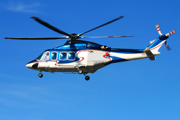 Fototapeta na wymiar Hovering helicopter on blue sky.