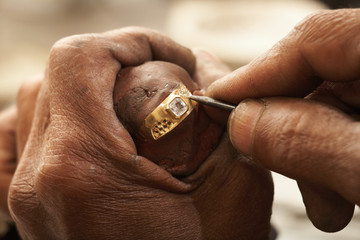 Goldsmith working on gold ring - 7414560