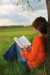Young women read book in garden - 7416504