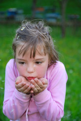 Cute girl blowing dandelion