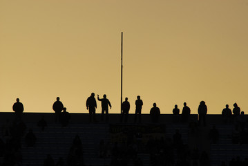 Soccer fans silhouettes in sunset