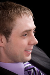 Fototapeta premium Portrait of happy businessman in suit over black background