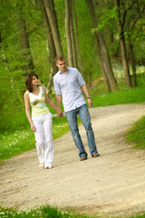 Naklejka na ściany i meble young and happy couple taking a walk in a park