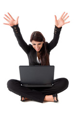 Happy business woman sitting on the ground with laptop