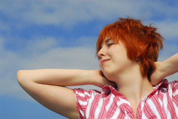 Woman with red hair on blue sky background