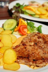 Pig meat with piquant sauce and roast potatoes