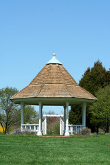 White gazebo in a park with blue sky