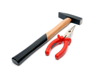 Hammer and flat-nose pliers with red handles isolated over white