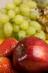 red apple with grapes as background