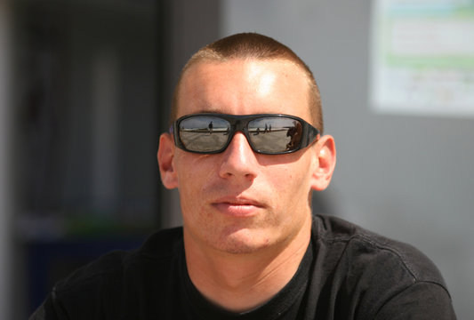 jeune homme avec des lunettes noires  de soleil