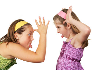 Two young girls fighting and sticking tout heir tongues out 