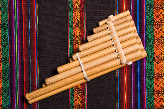 siku andean wind musical instrument on traditional tapestry