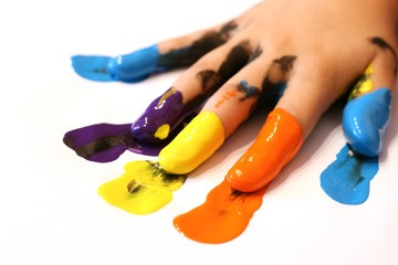 Kinderhand mit bunten Farben an den Fingern 