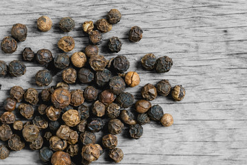 Pepper grains on wooden table