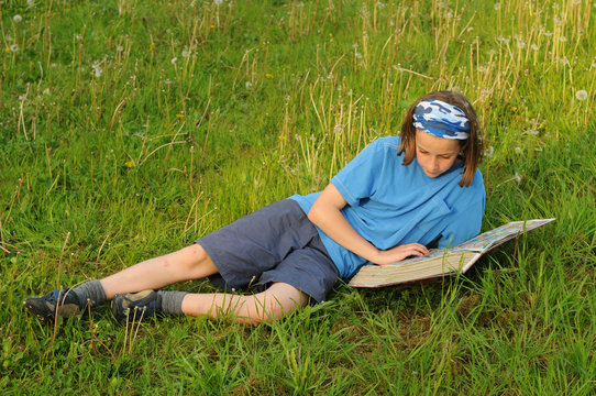 girl lying in field reading